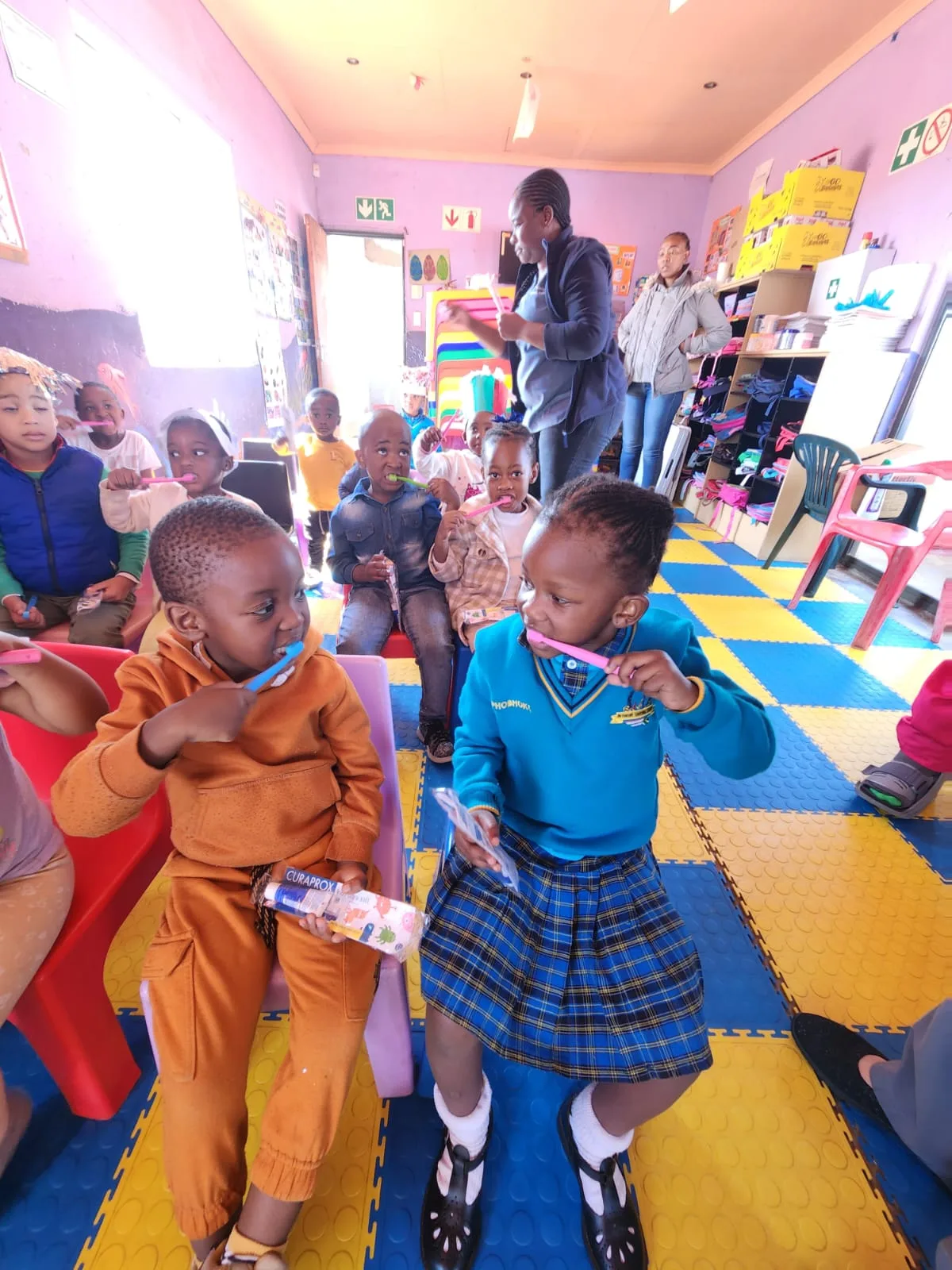 Children at a community school learning to brush their teeth during a Smile High dental education session